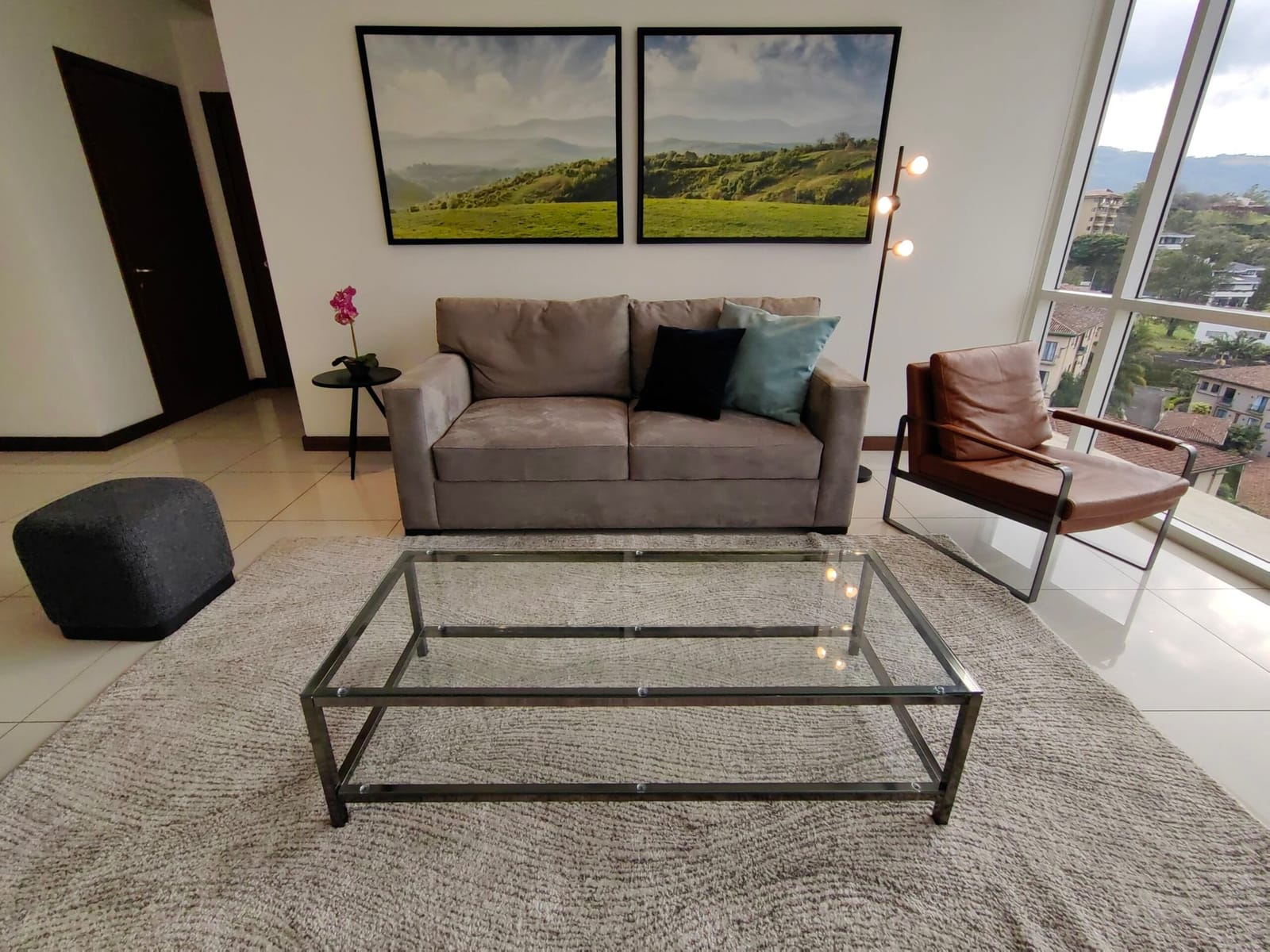 Sectional sofa, glass coffee table and framed landscape prints