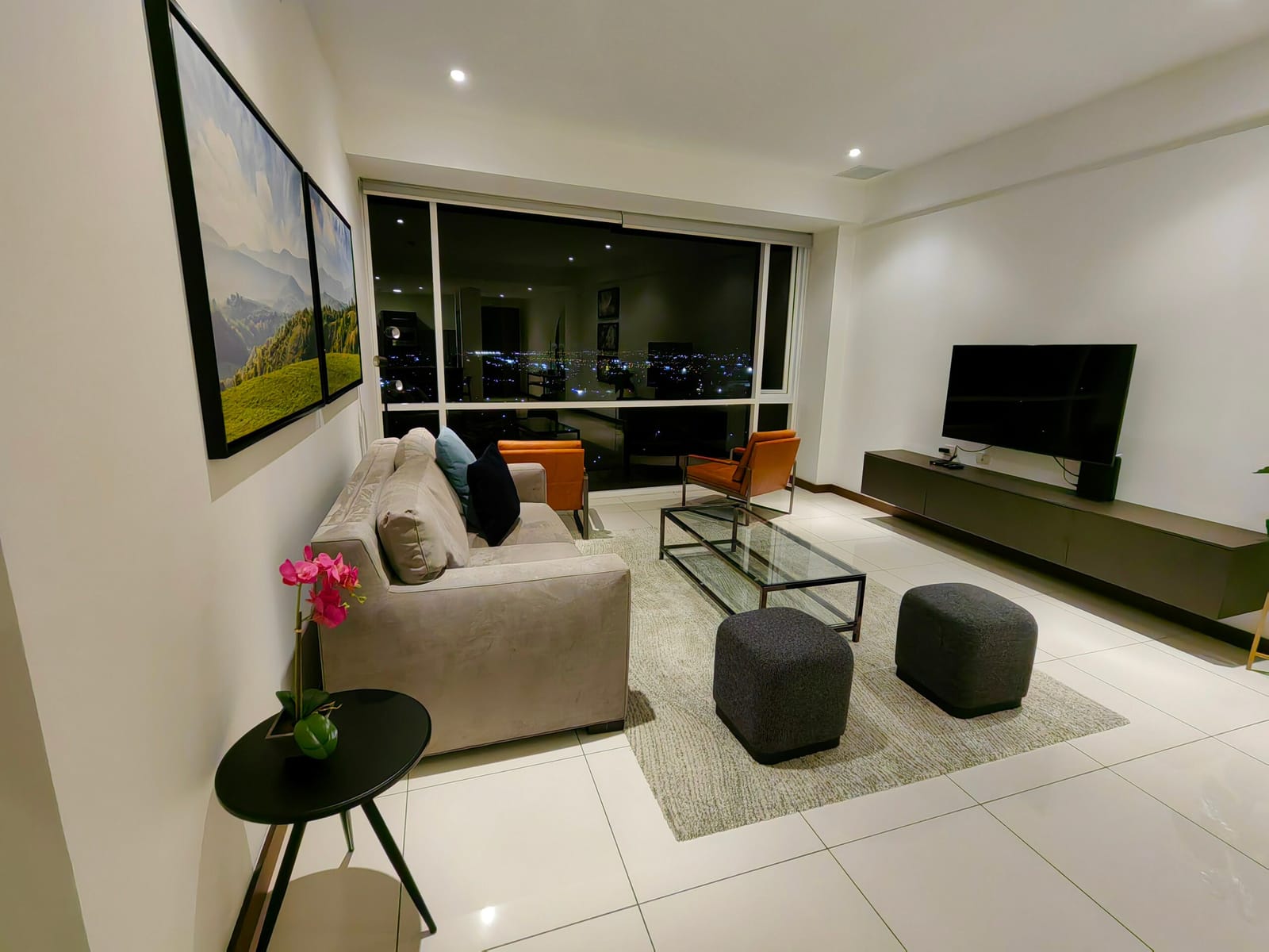 Living room lit at night with the sofa and TV
