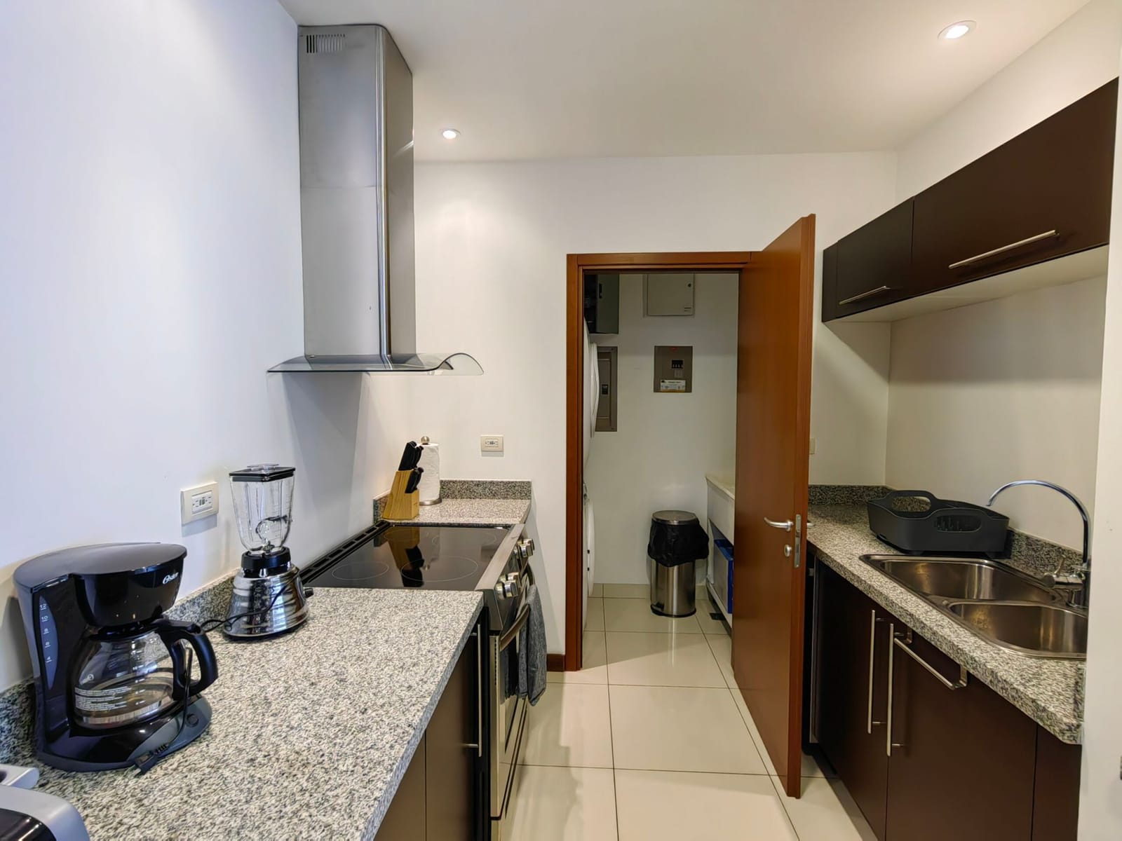 Kitchen with coffee maker, blender and stainless range hood