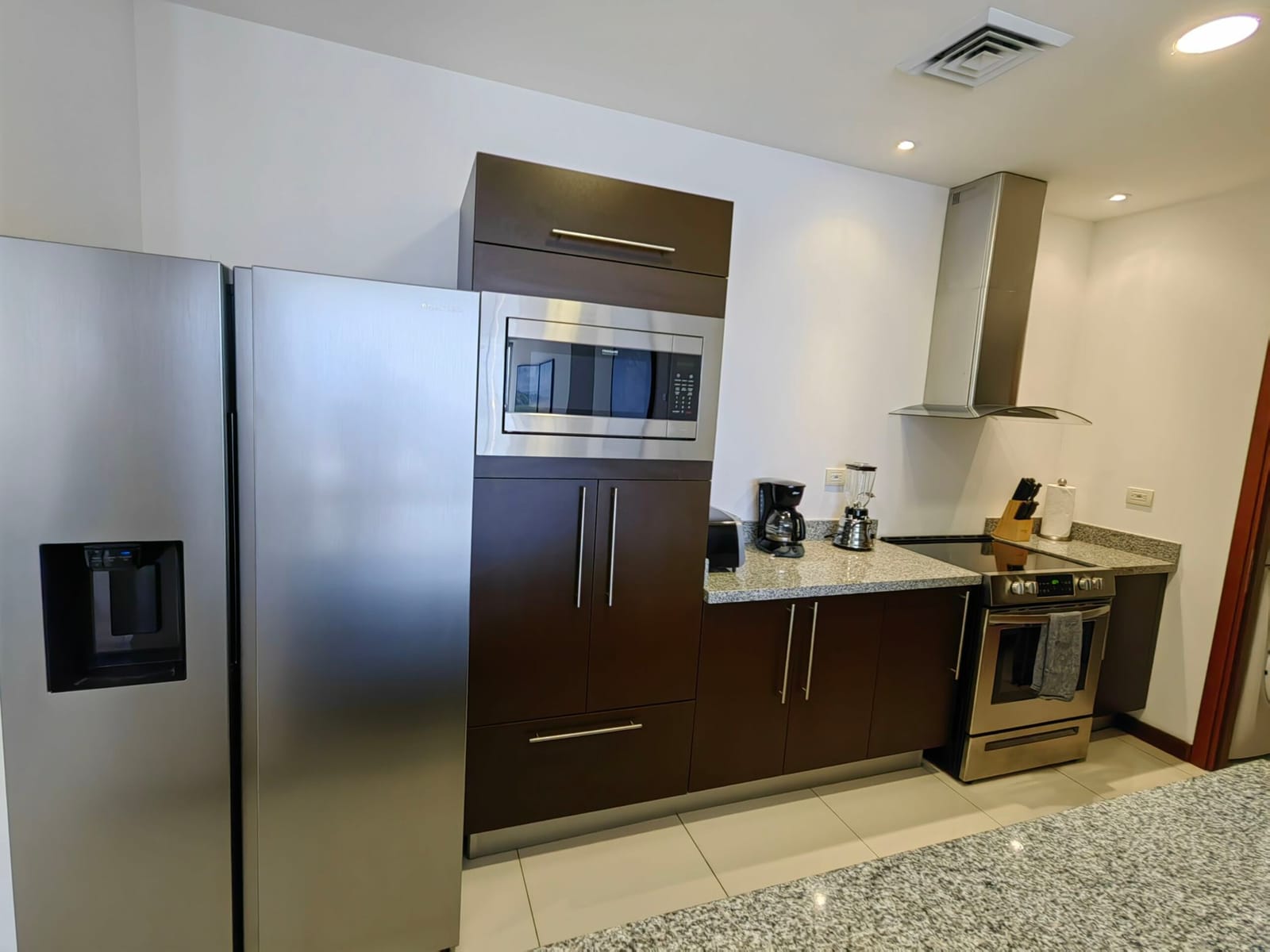 Stainless refrigerator, built-in oven and coffee maker in the kitchen