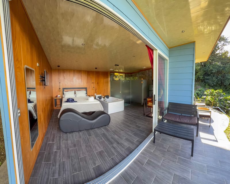 Open glass front of the cabin with the bed and deck seat