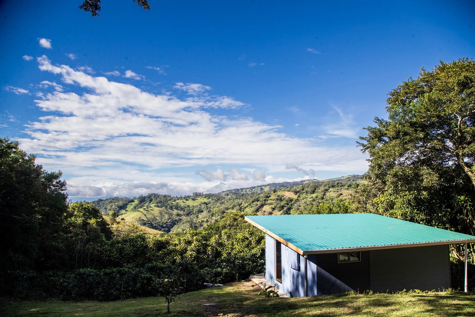 Turquoise-roofed farm building with the wide valley behind it