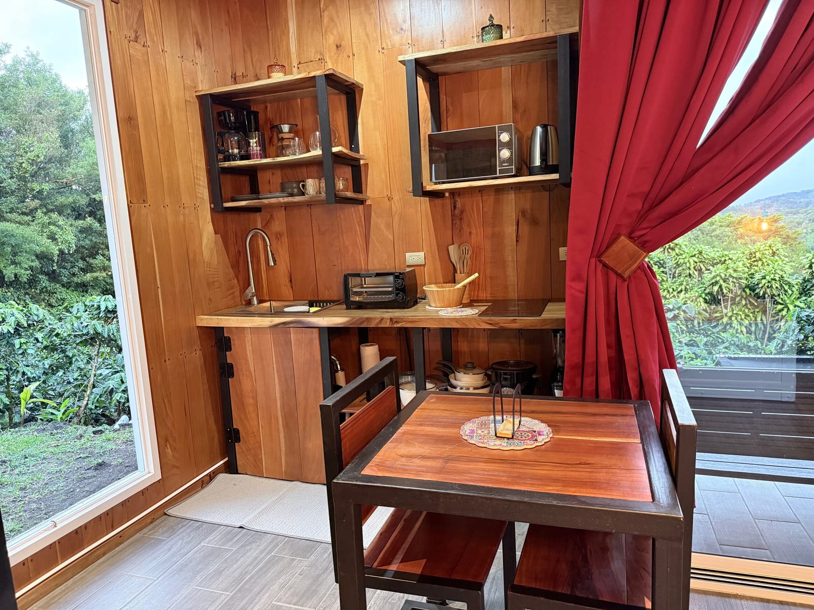 Kitchenette with cooktop, shelves and table by the window