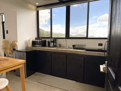 Kitchenette under a corner window with hills beyond