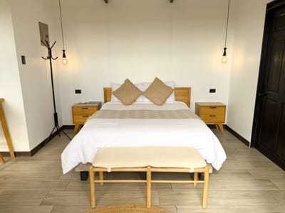 Queen bed with cushions, bench and pendant lights