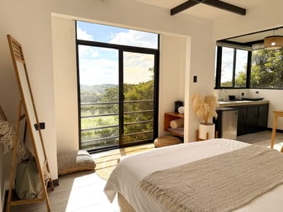 Bed with fringed throw beside the balcony door