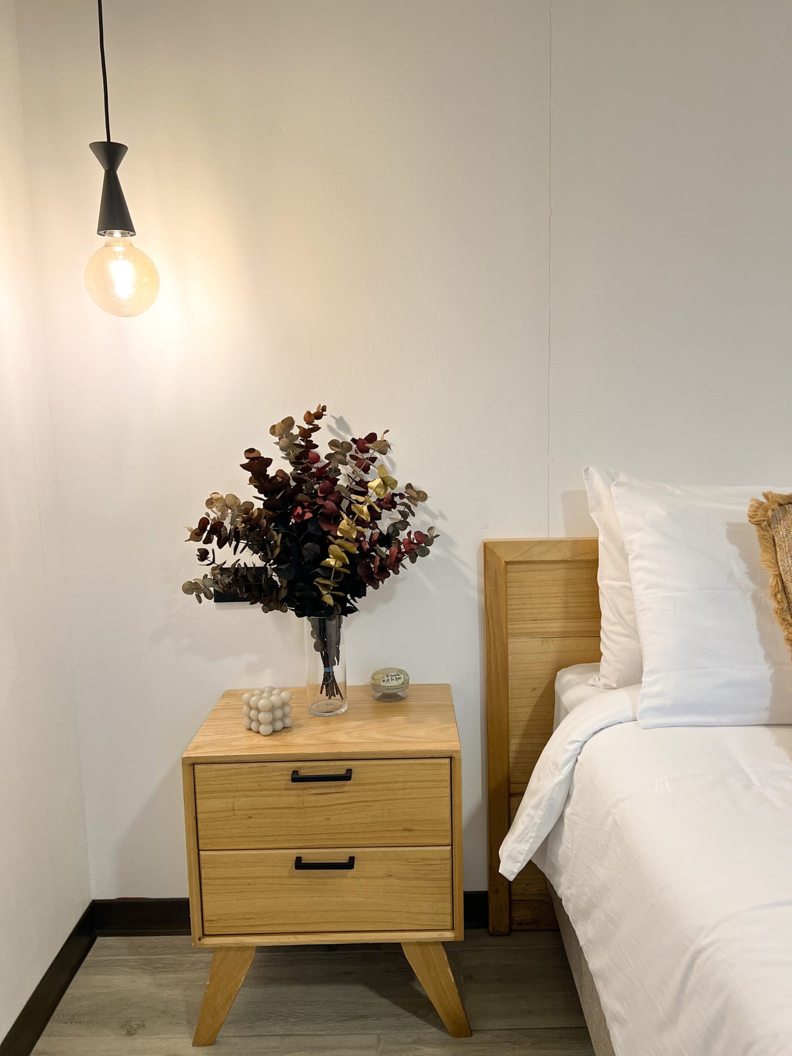 Pendant bulb over the bedside table and pillows