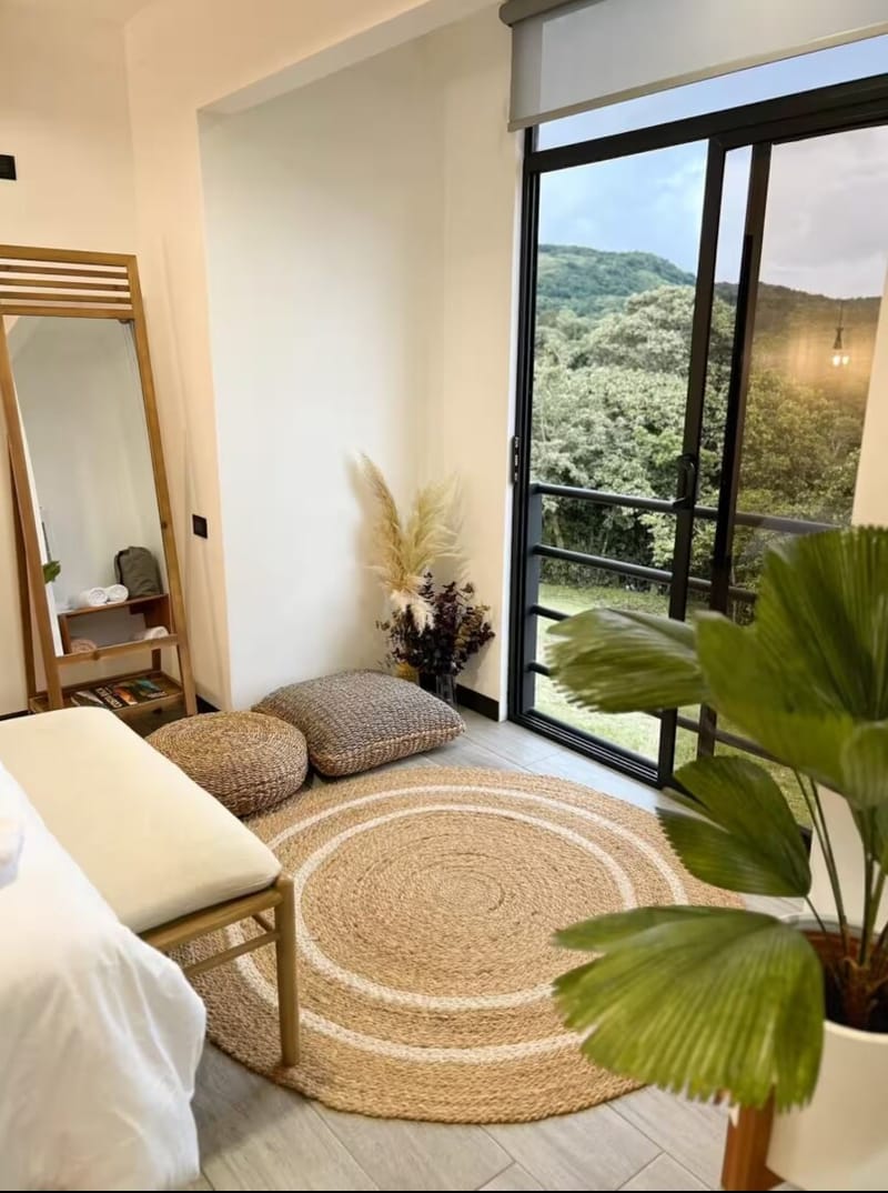 Mirror, bench and open balcony door with hills