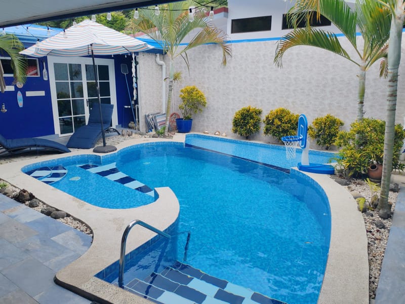 Kidney-shaped pool in the courtyard of the blue and white house