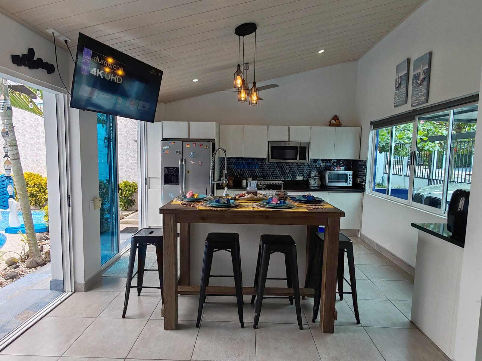 Kitchen island with stools and TV under the pitched ceiling
