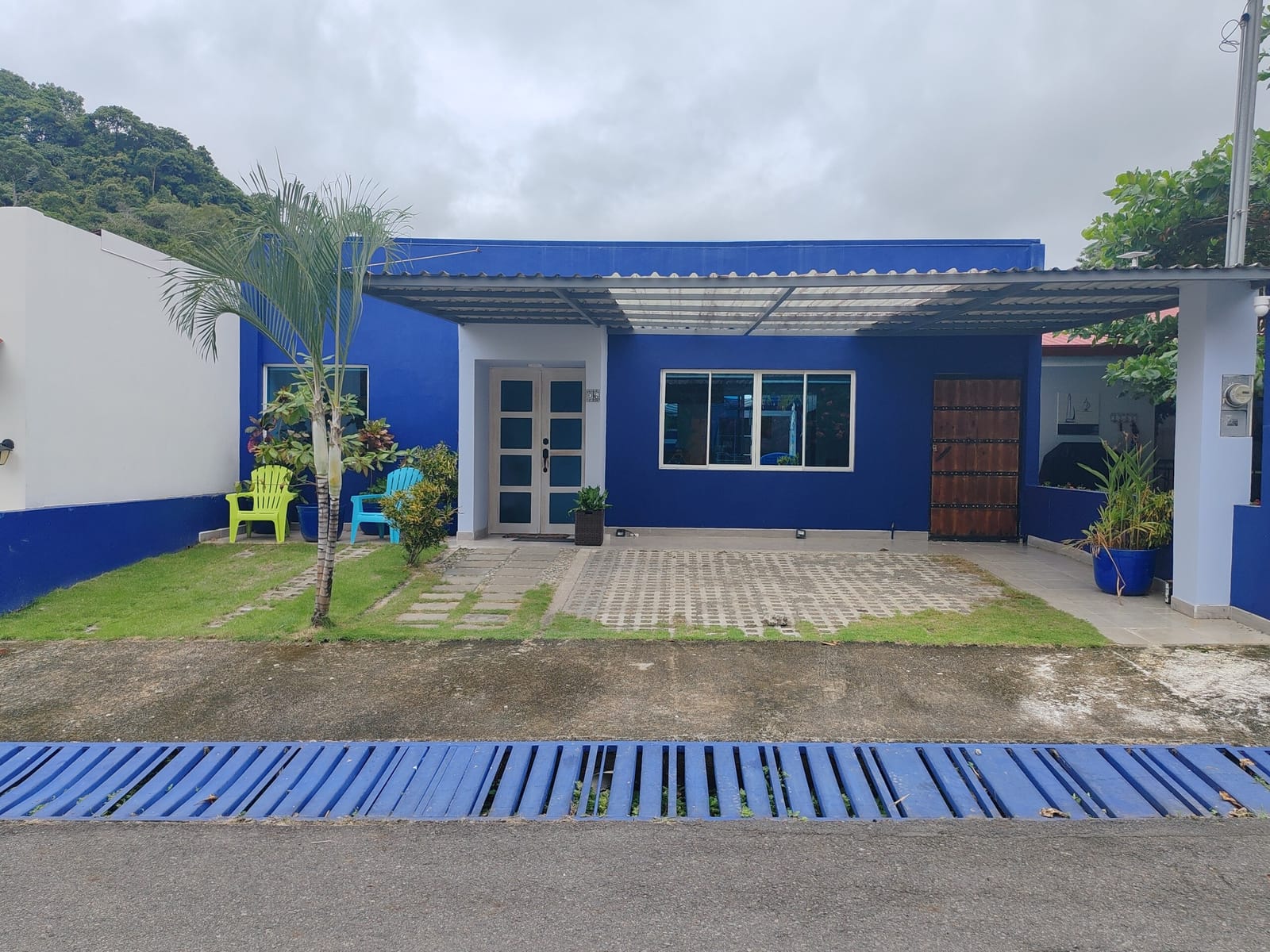 Front of Casa Azul with lawn strip and blue curb