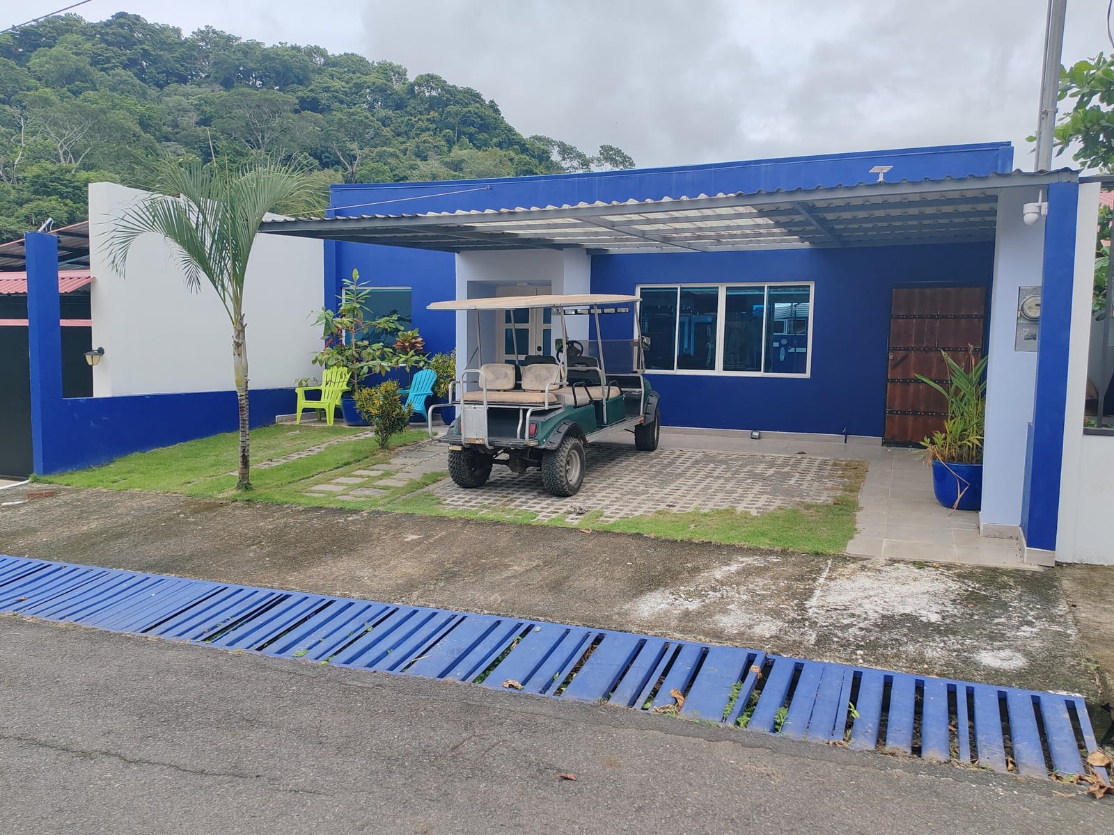 Golf cart parked at the entrance of the blue house