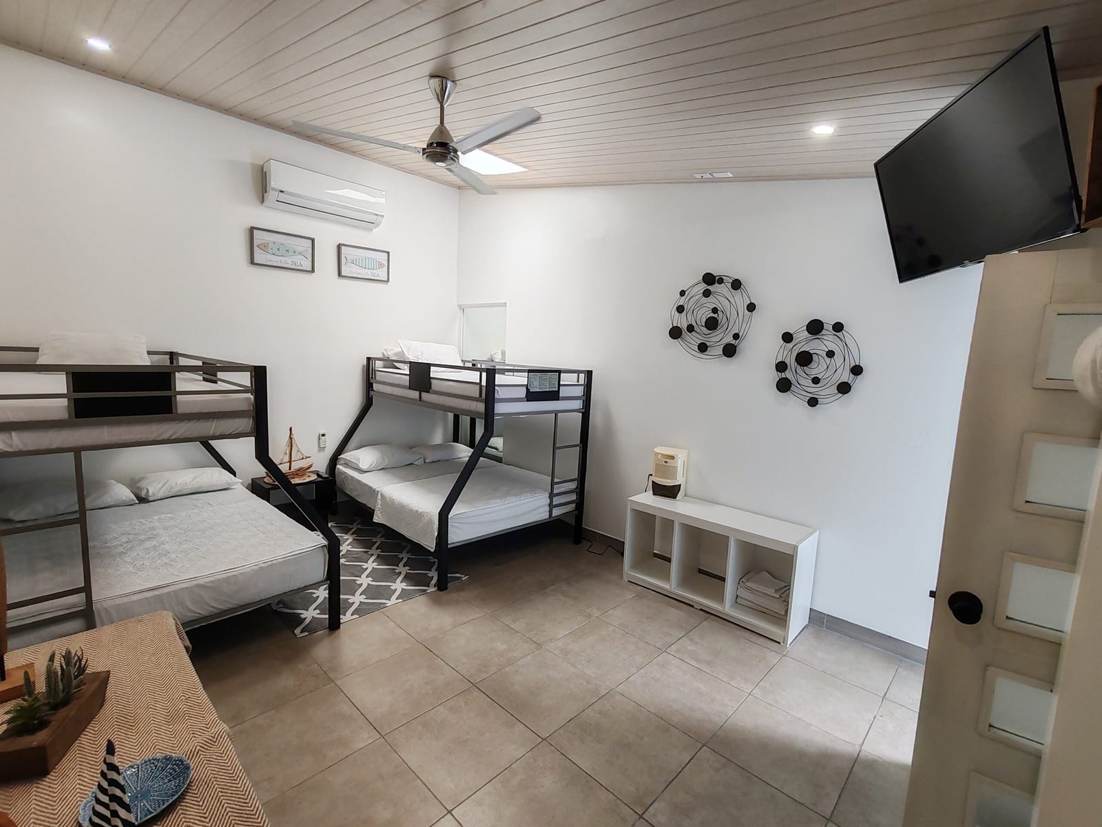 Bunk room with wall TV, AC unit and ceiling fan