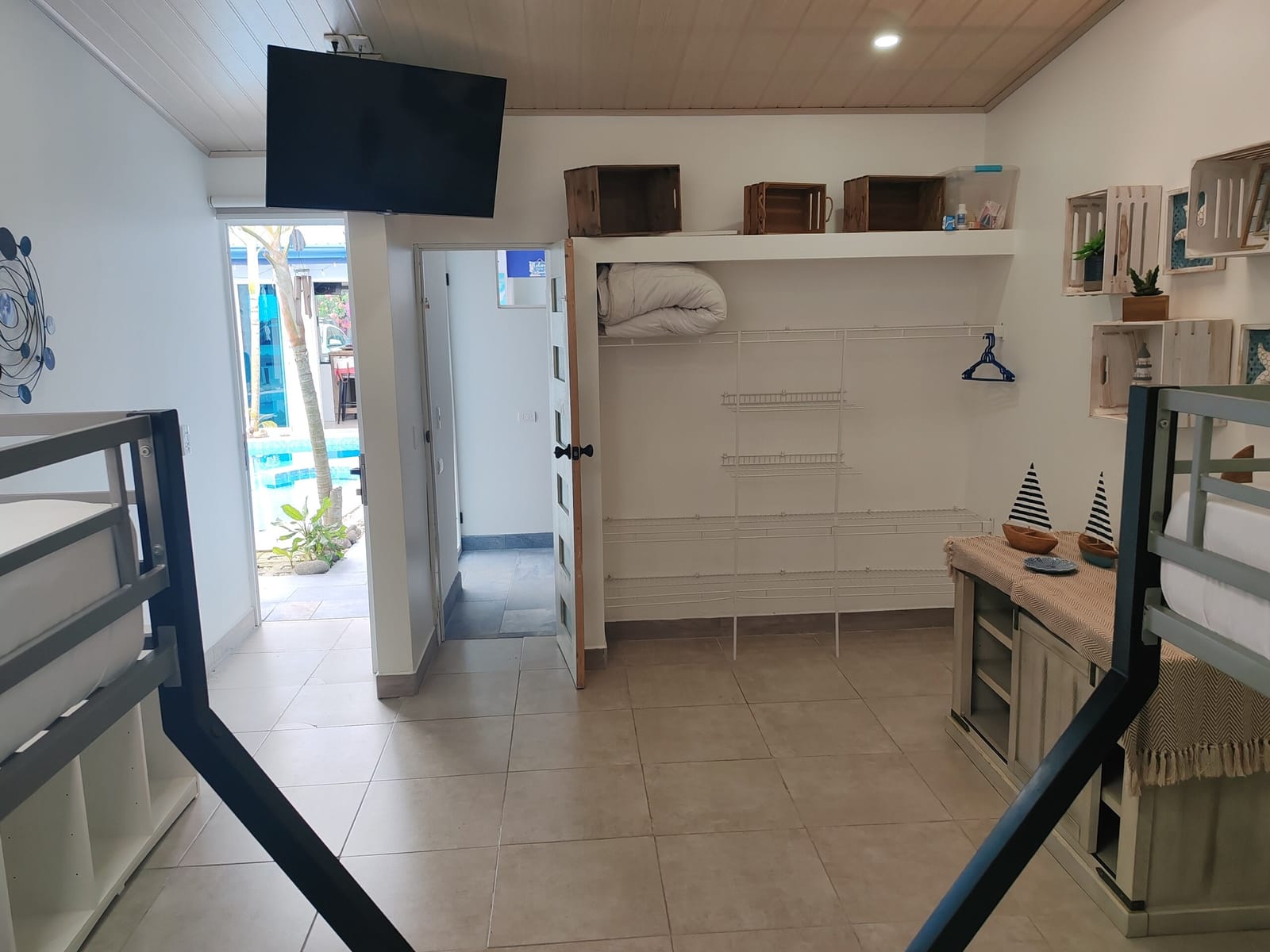 TV, dresser and bunk bed with the pool outside