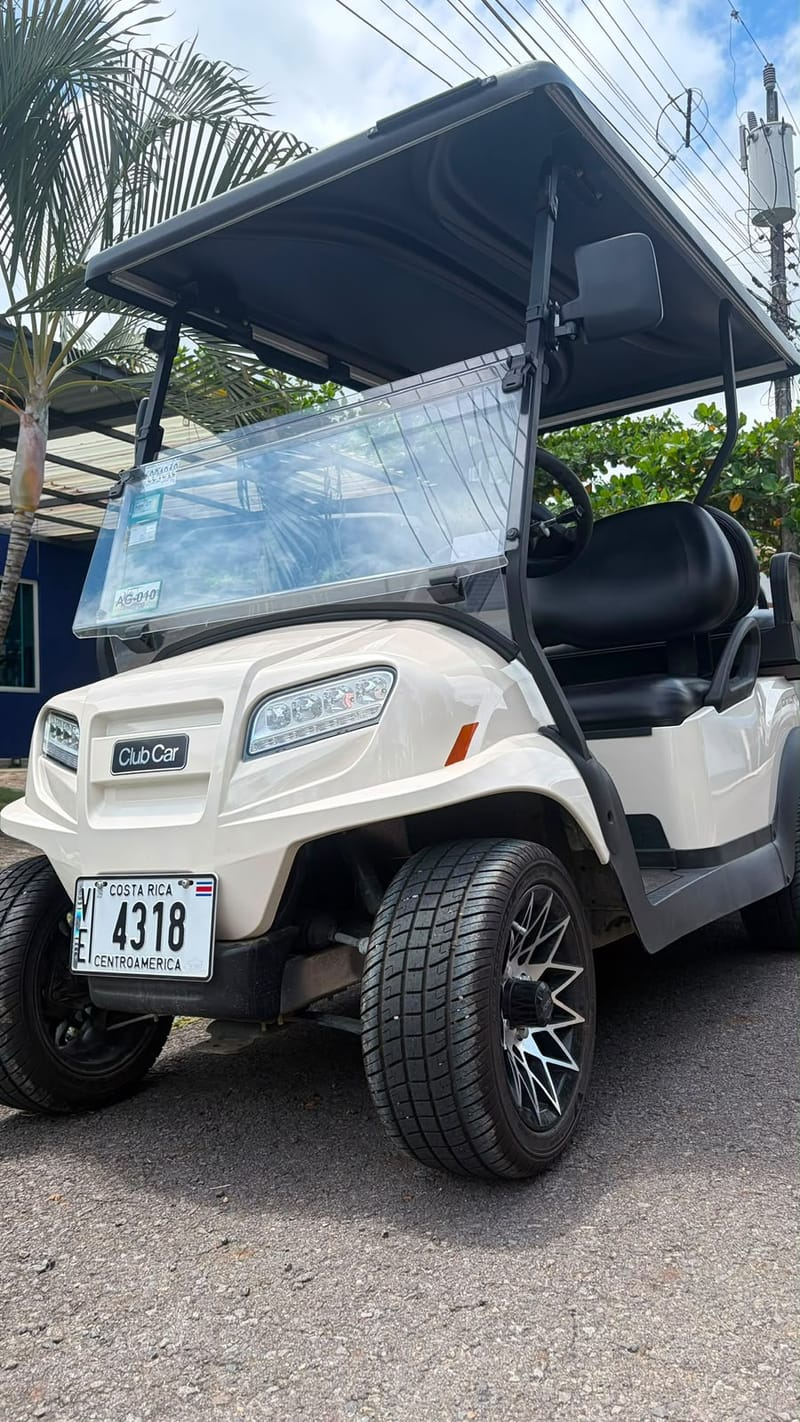 Club Car golf cart with a windshield, parked on the street