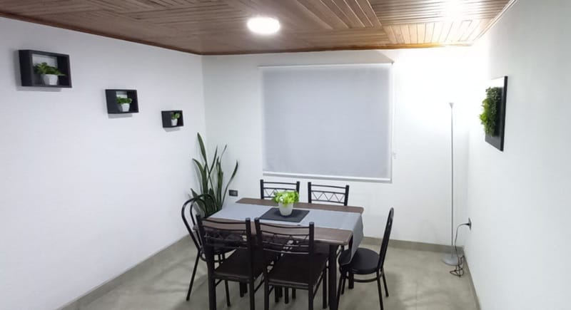 Dining table for four by the window with roller blinds
