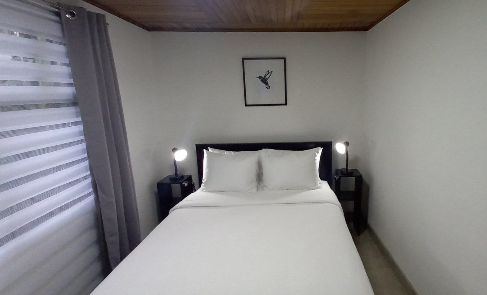 Bedroom window with sheer blinds beside the bed