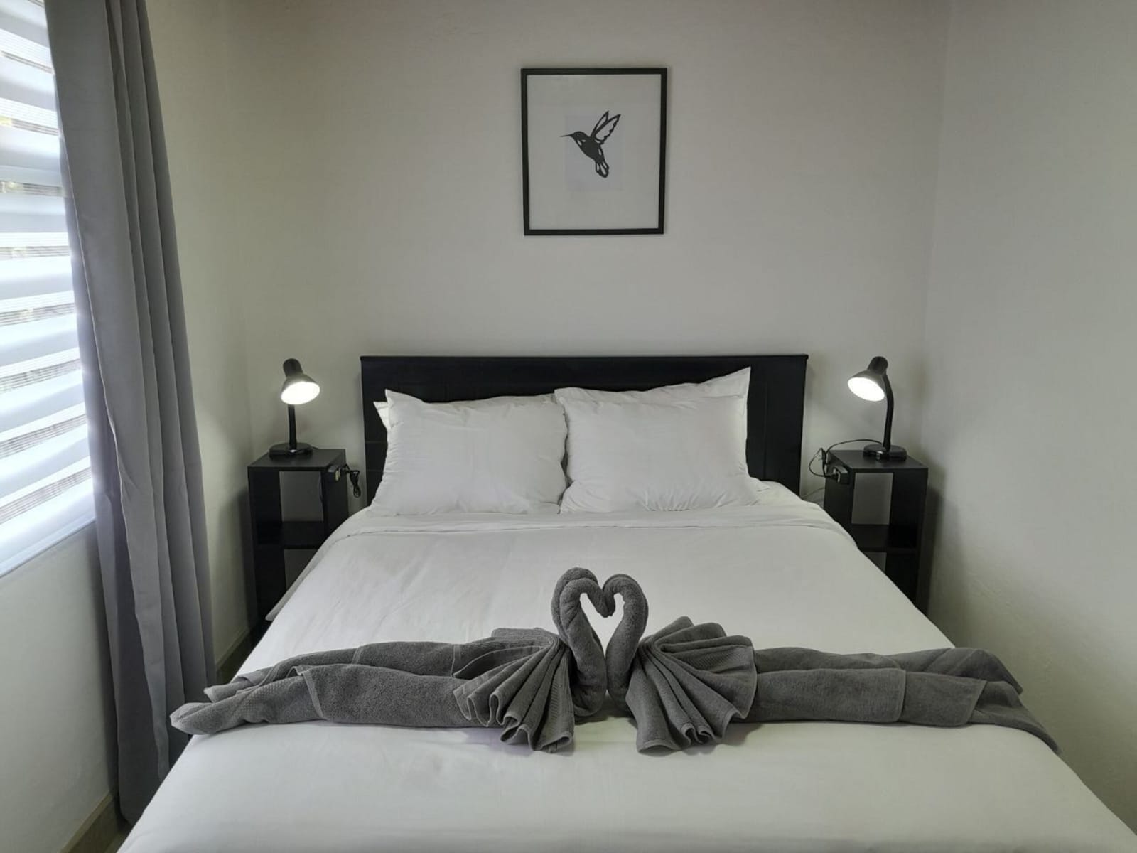 Bed with towel swans and lamps on both sides