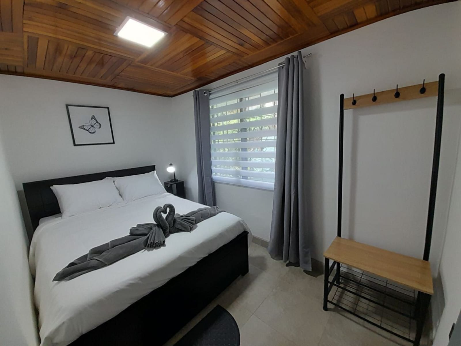 Bedroom with wooden bench, hooks and a window