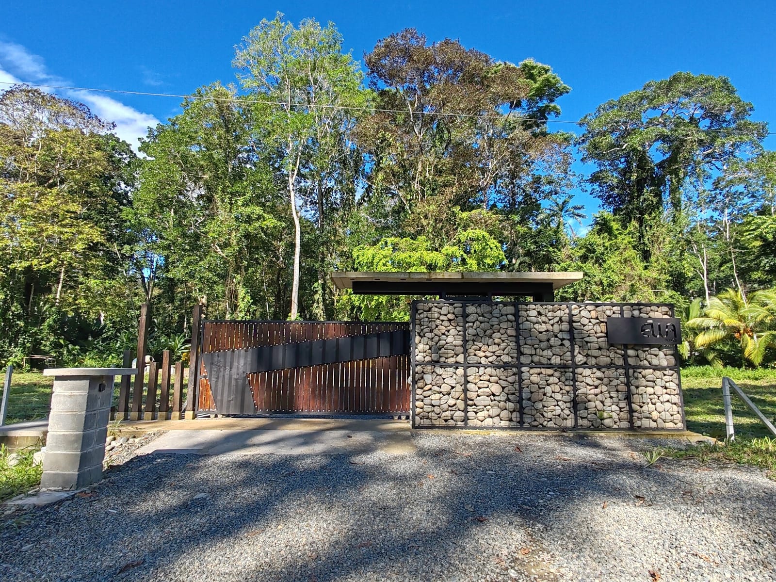 Gabion stone wall and rust gate at the property entrance