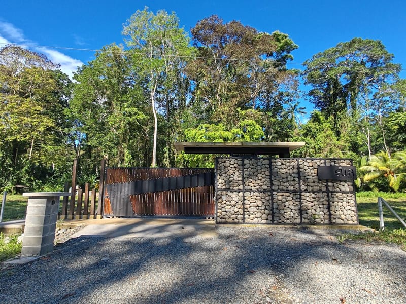 Gabion stone wall and rust gate at the property entrance