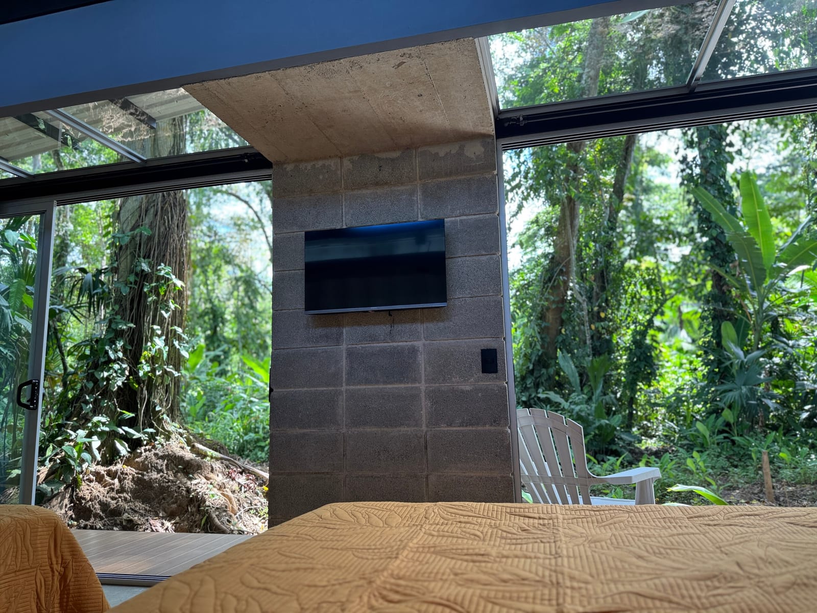 Wall-mounted TV on the block wall seen from the bed