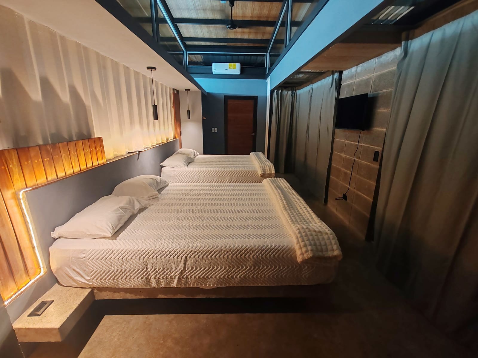 Two queen beds with lit headboard and AC unit above