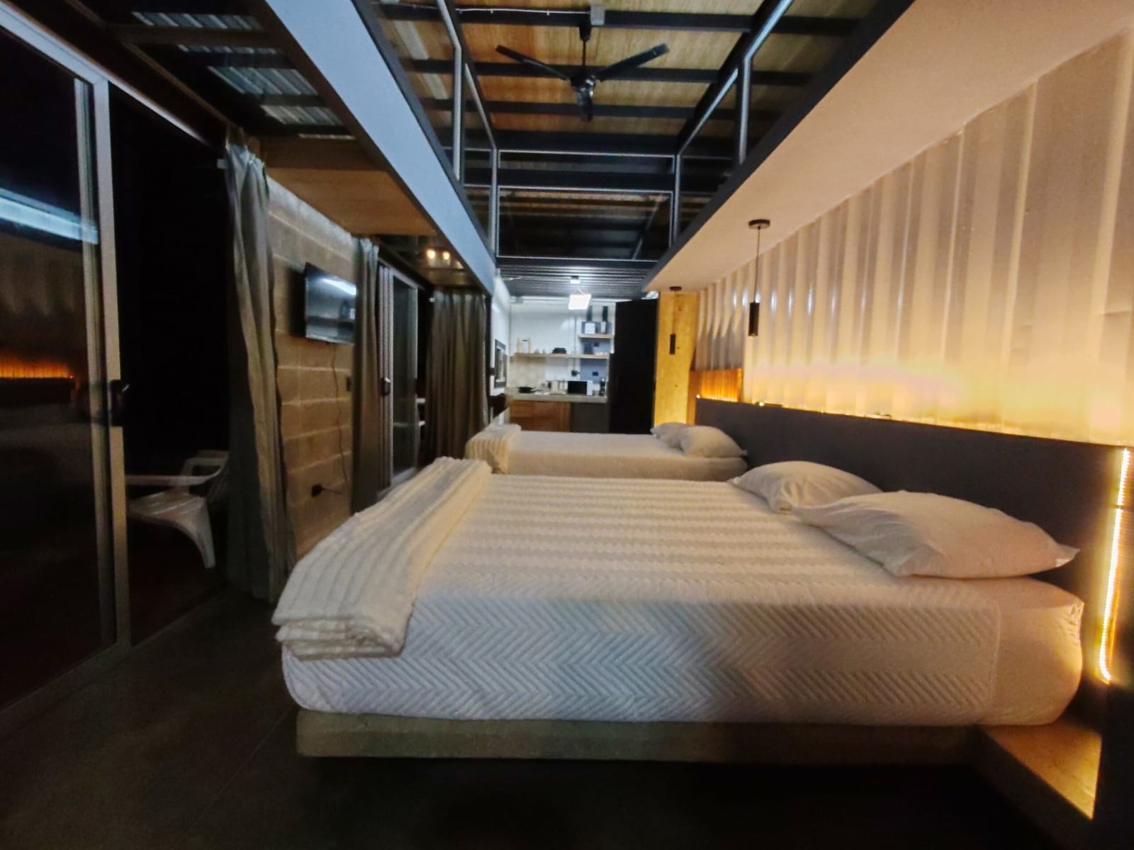 Two beds under the lit headboard facing the door