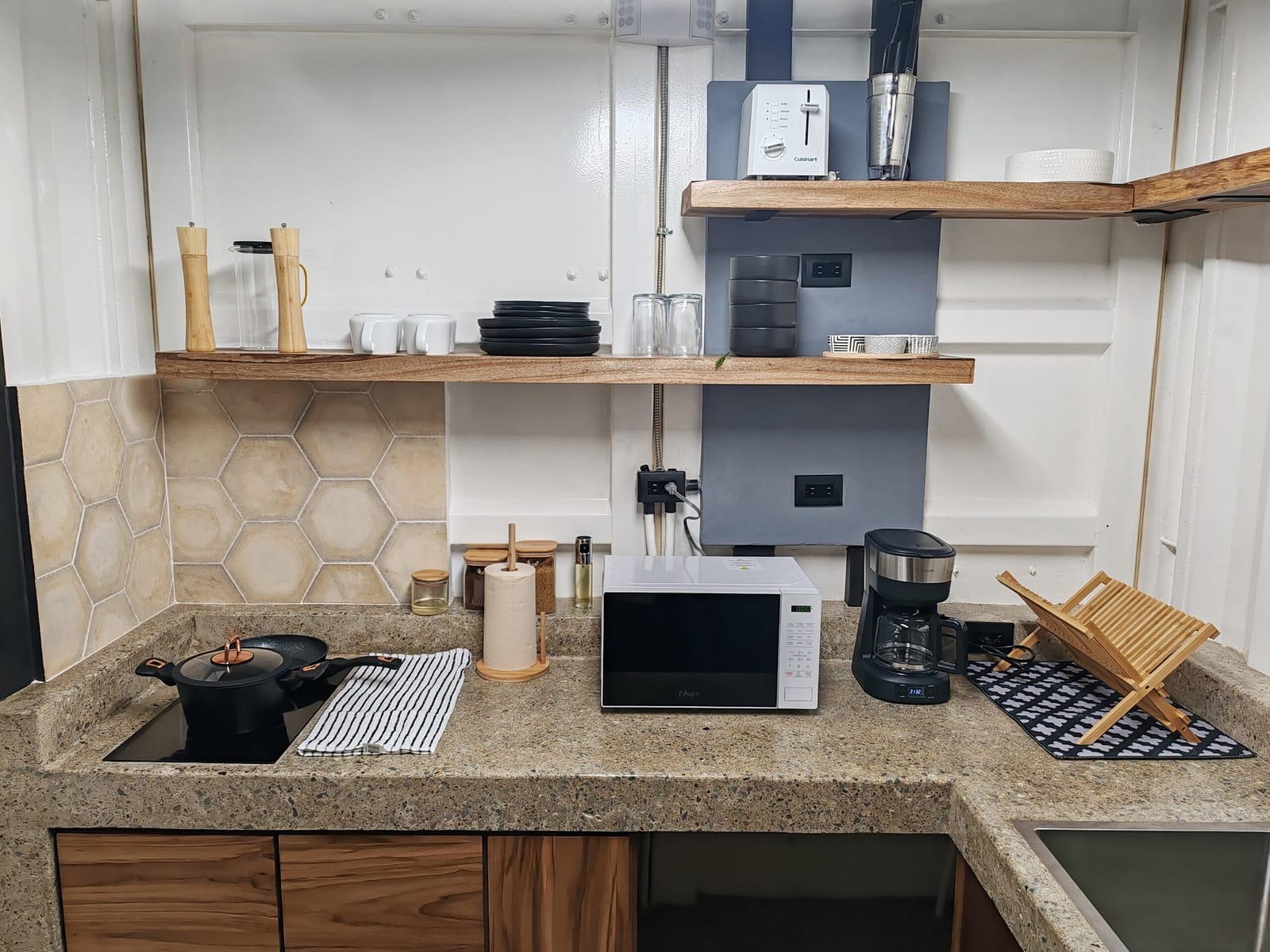 Induction stove, microwave and coffee maker on the granite counter