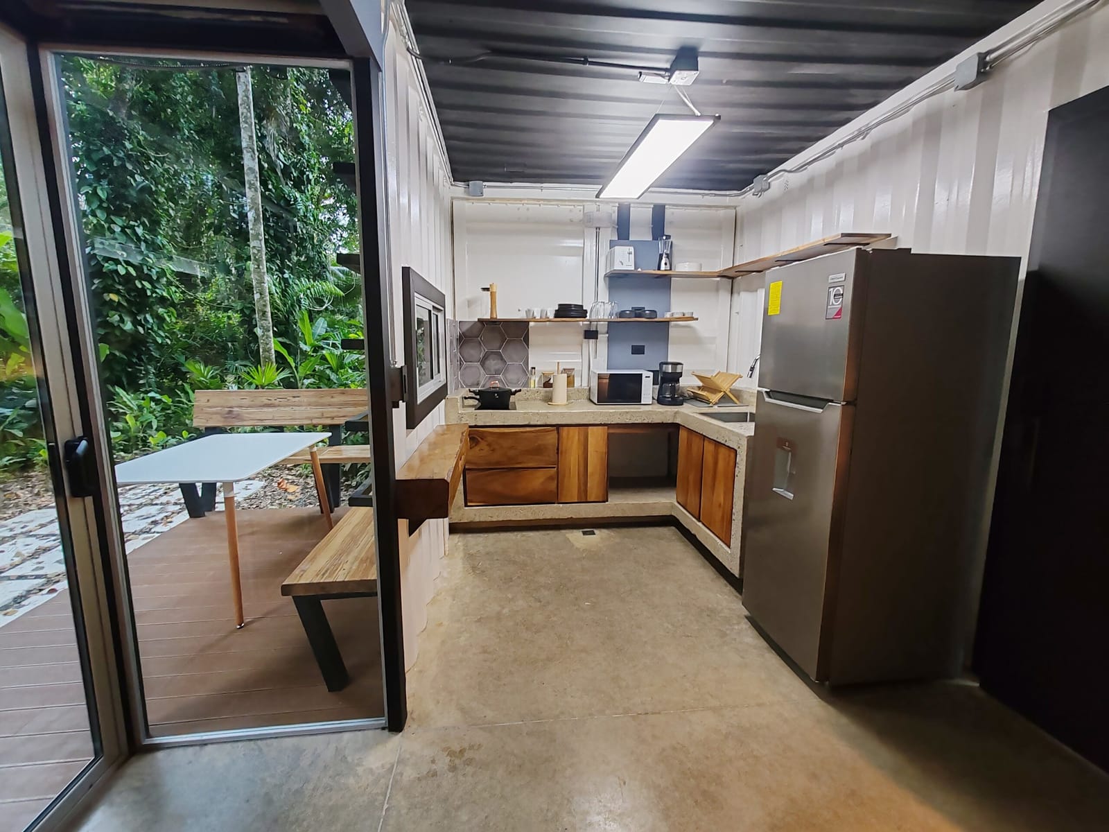 Kitchenette opening to the deck table and the trees