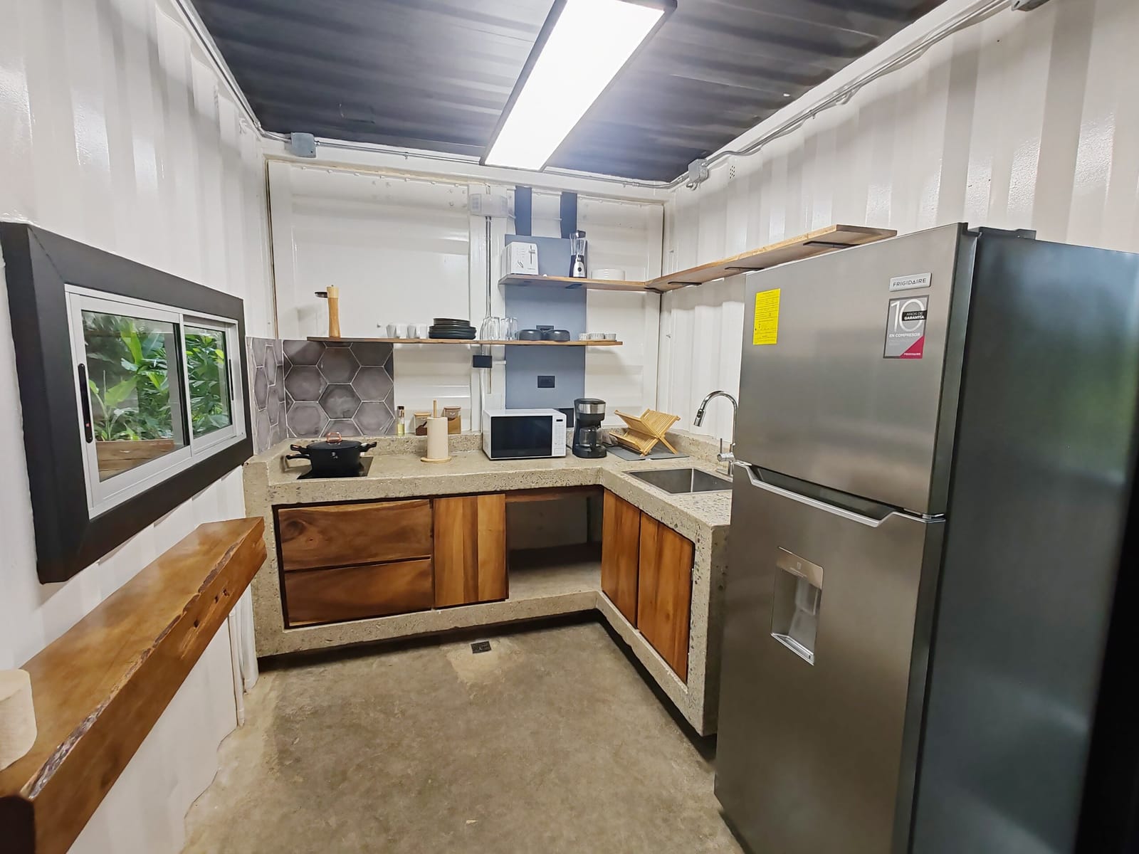 Kitchenette with window over the sink and open shelving