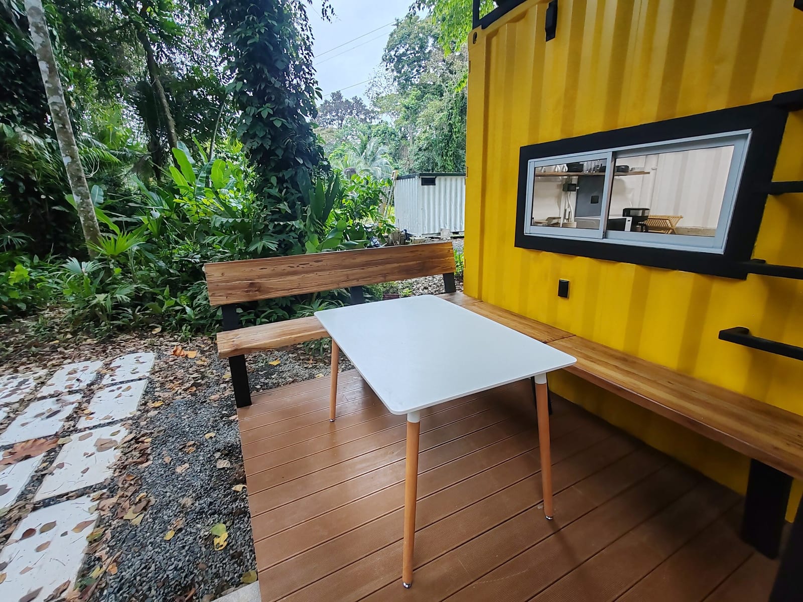 Outdoor dining table on the deck with jungle behind