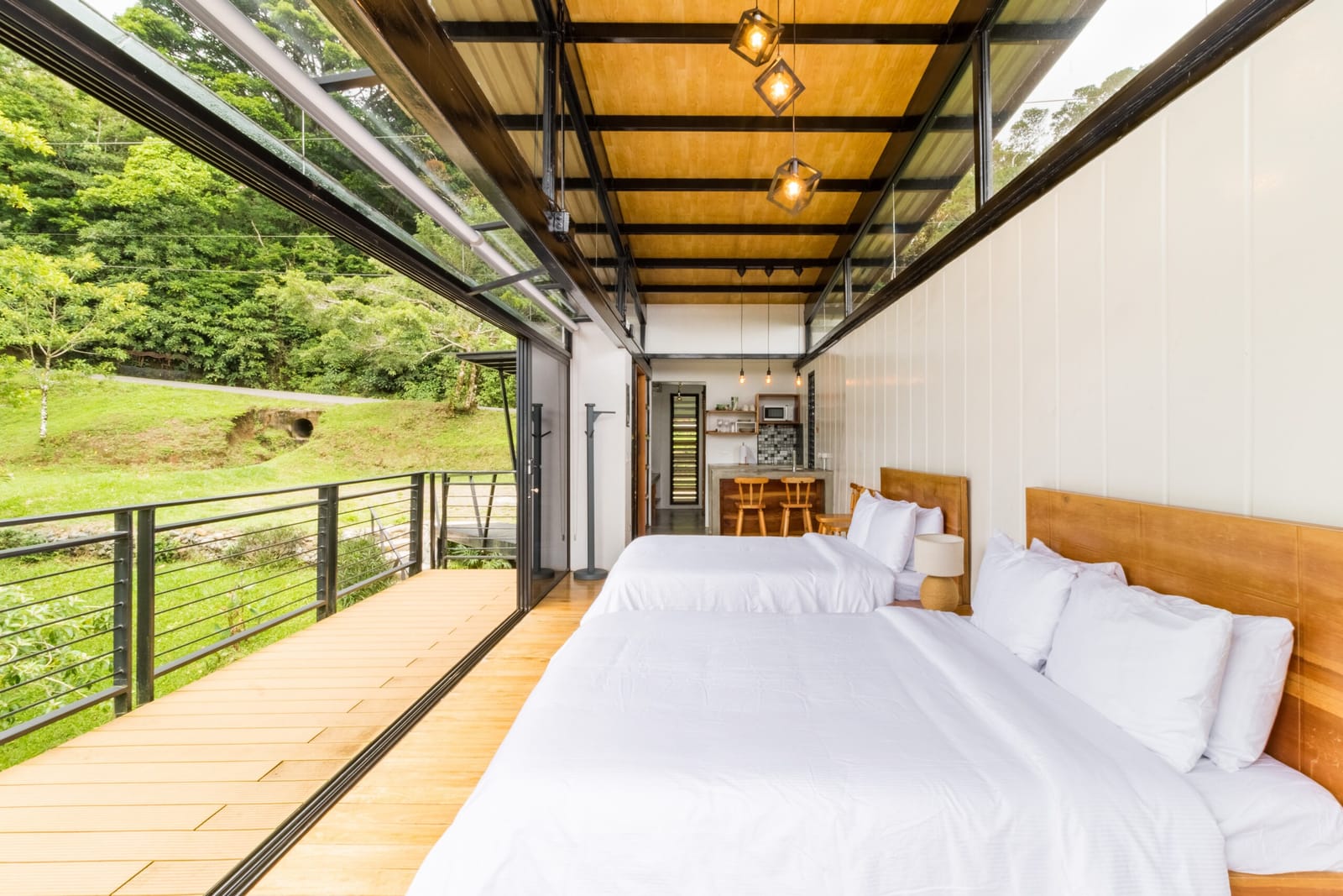 Beds and deck under the wood ceiling, forest on the left