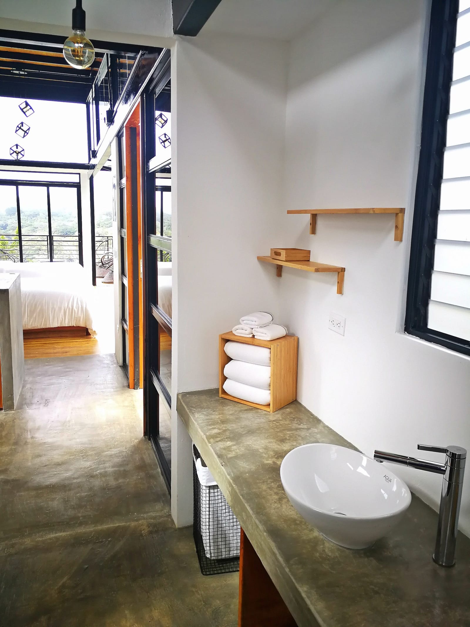 Bathroom shelf with folded towels and a small window