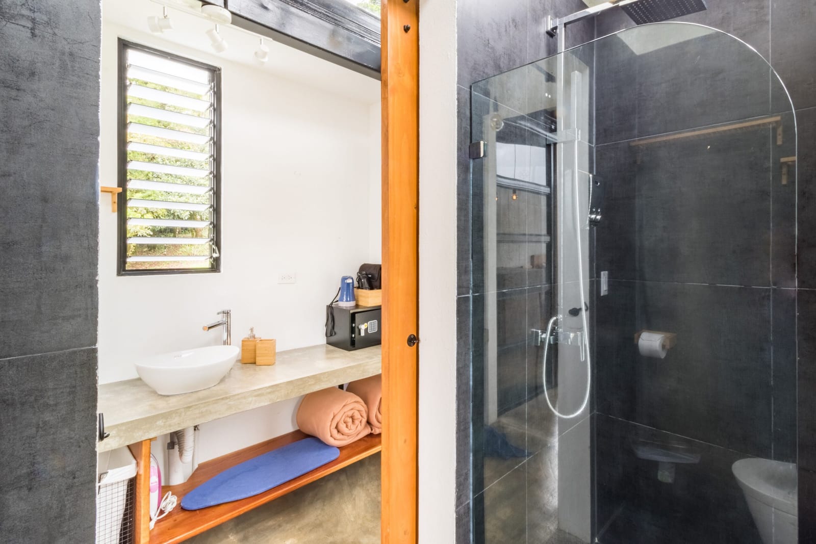 Bathroom with vanity, toiletries and glass shower door