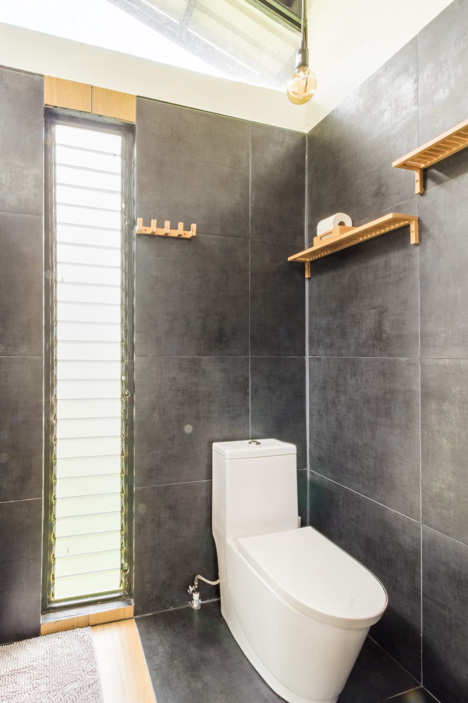Bathroom with louvered window, wooden hooks, shelf and toilet