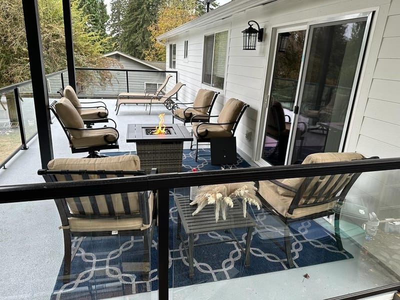 Covered deck with cushioned chairs around the fire pit table