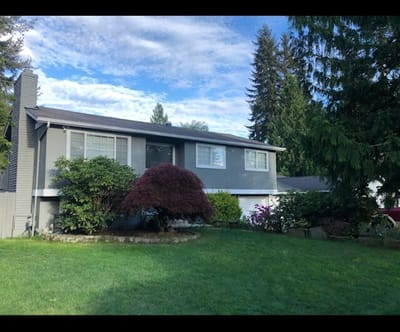 Gray two-story house with lawn and a red maple