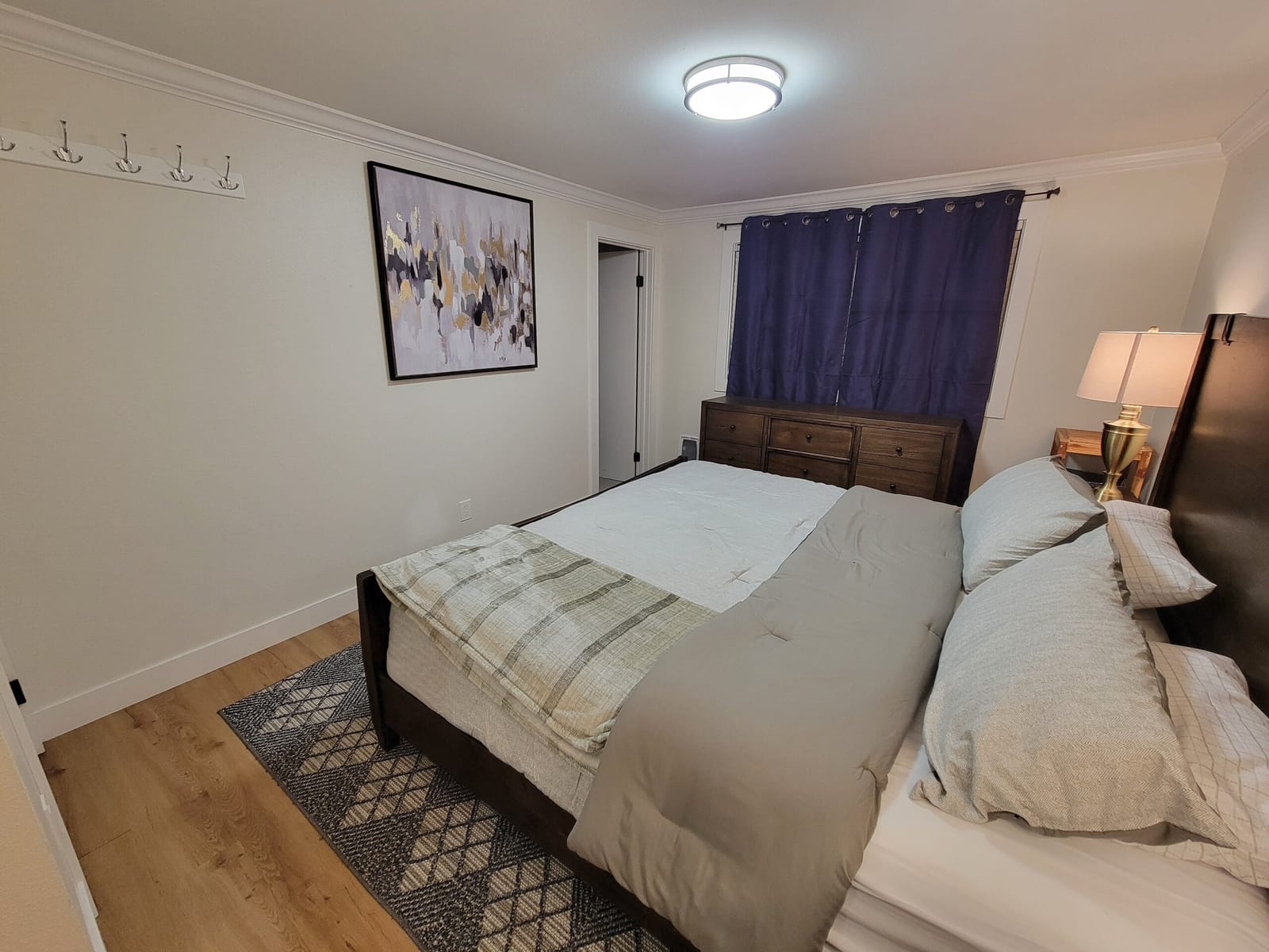 King bedroom with navy curtains and framed art