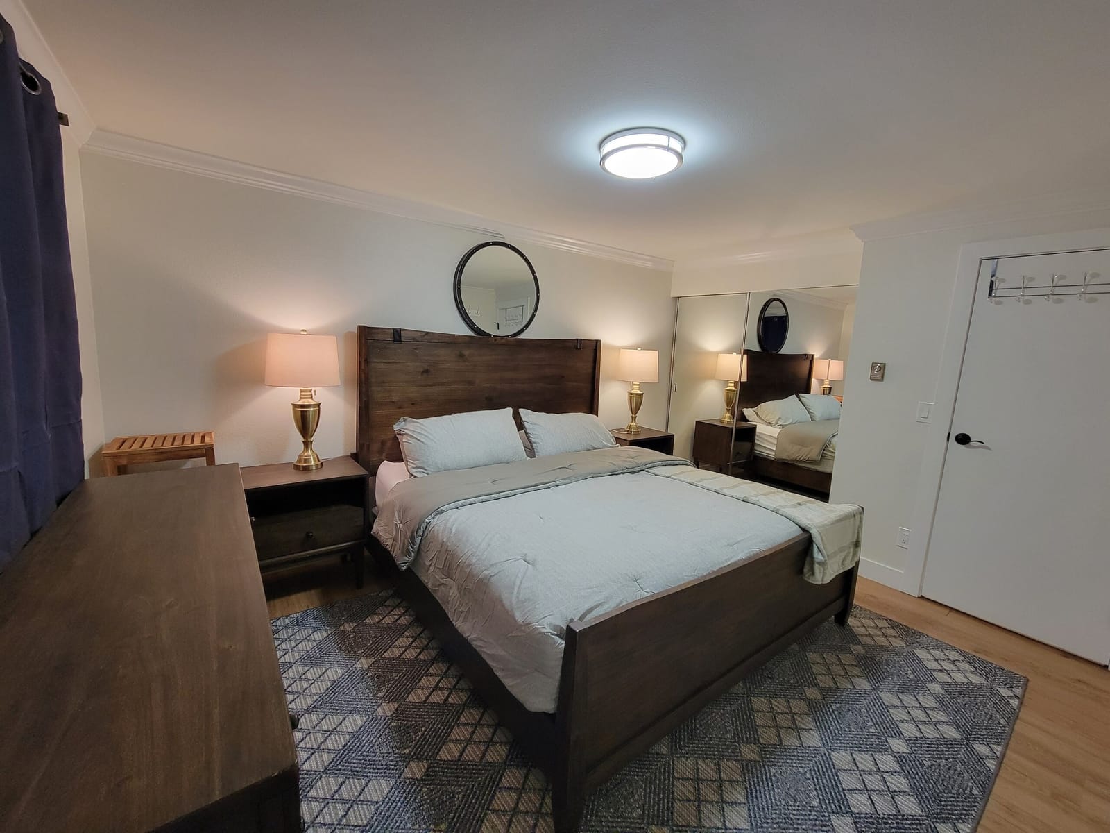 King bed with bedside lamps and mirrored closet doors