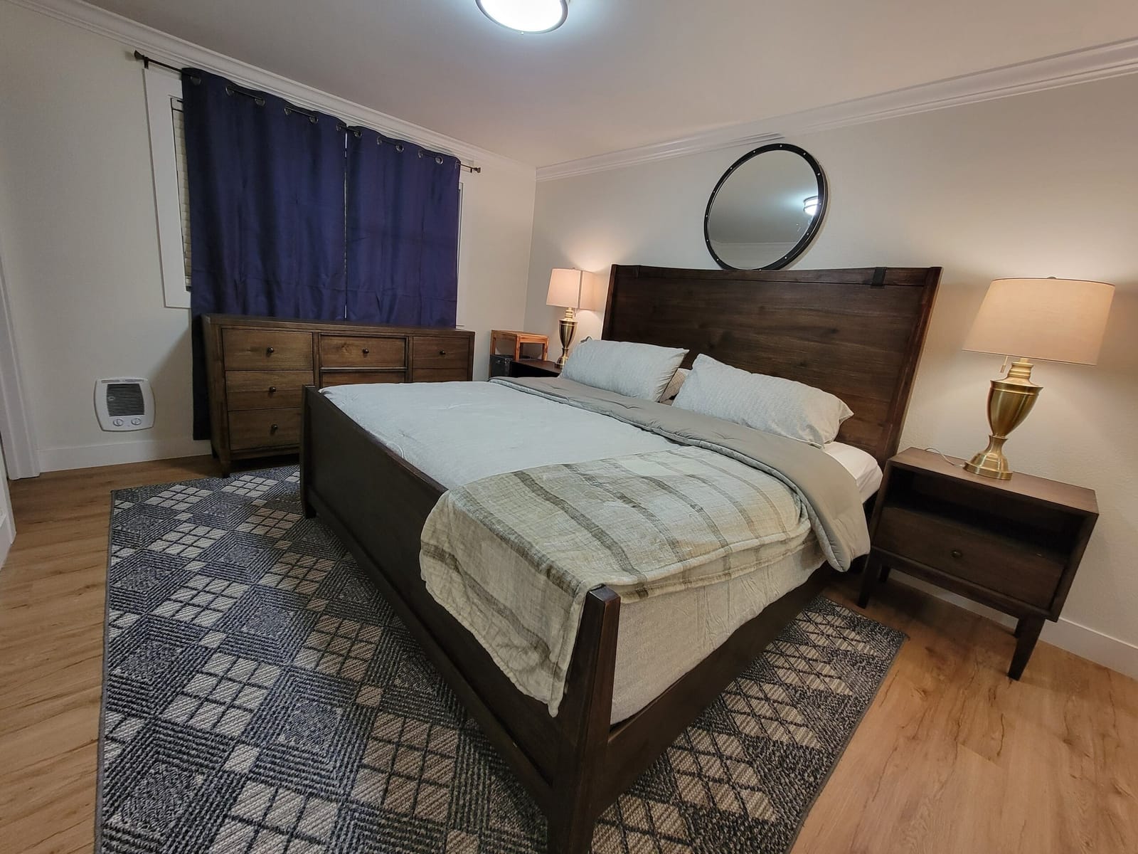 King bed with striped throw and two bedside lamps