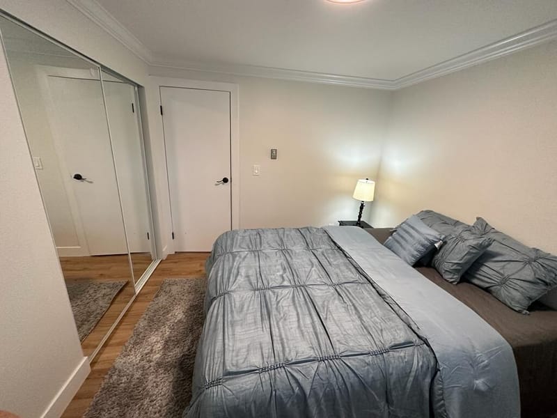 Second bedroom with gray bedding and mirrored closet