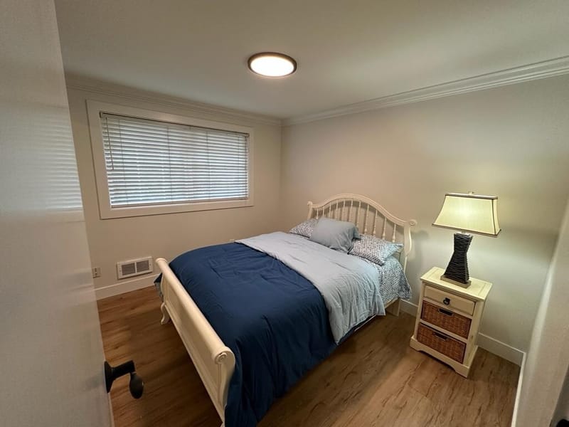 Third bedroom with white iron bed and blue quilt