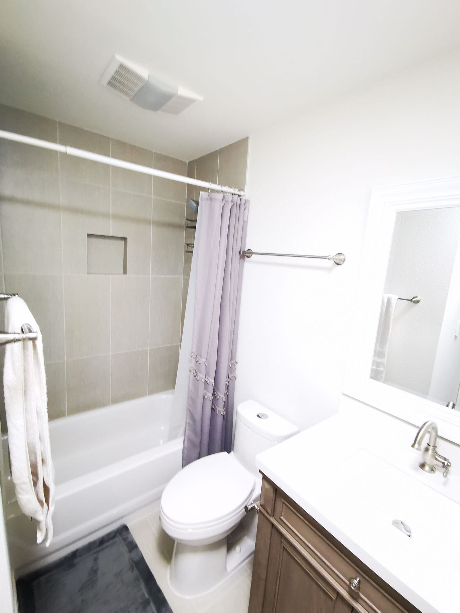 Second bathroom with tub-shower, curtain and white vanity