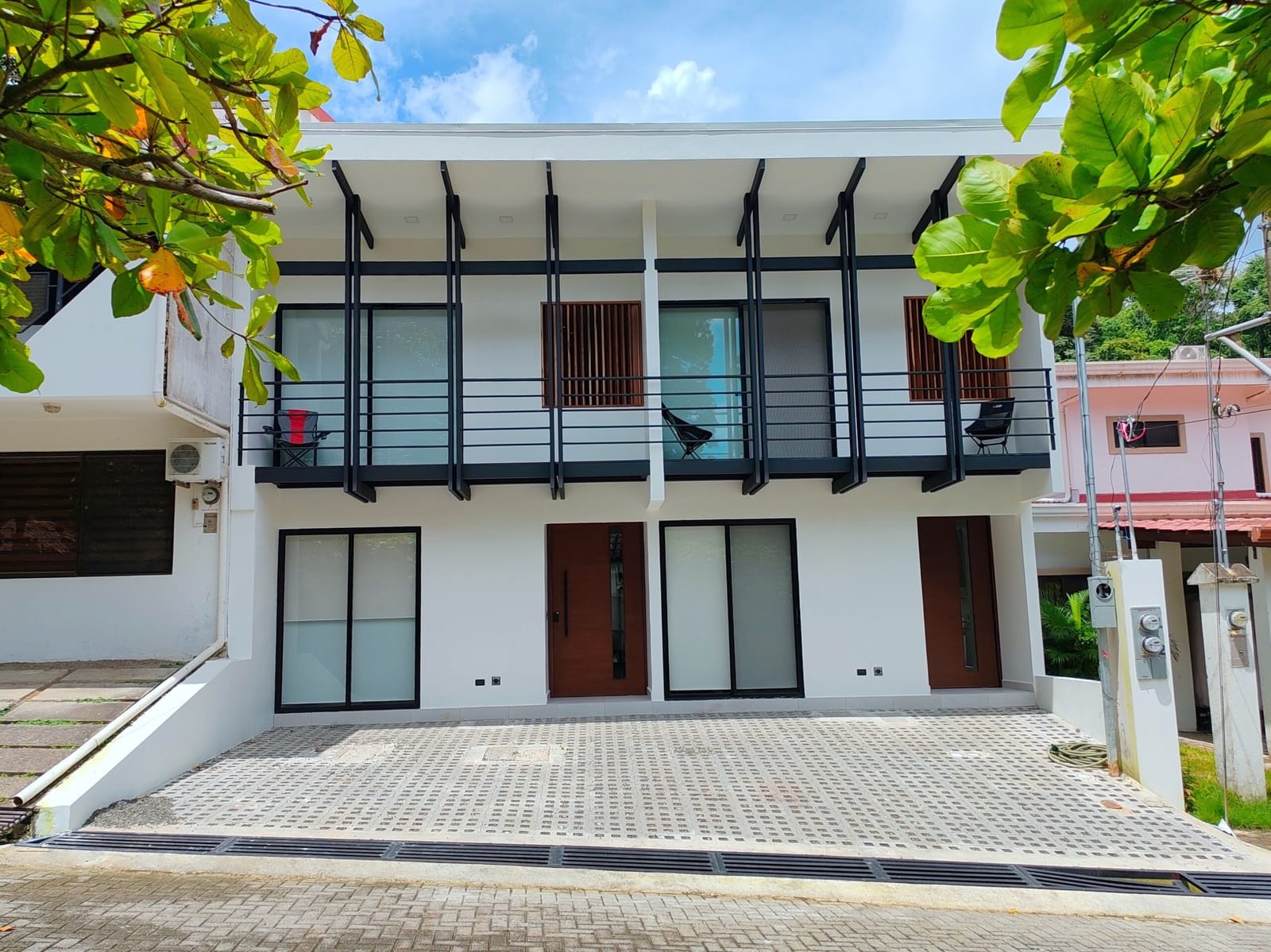 Two-story white building with twin front doors and balconies