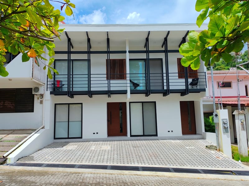 Two-story white building with twin front doors and balconies