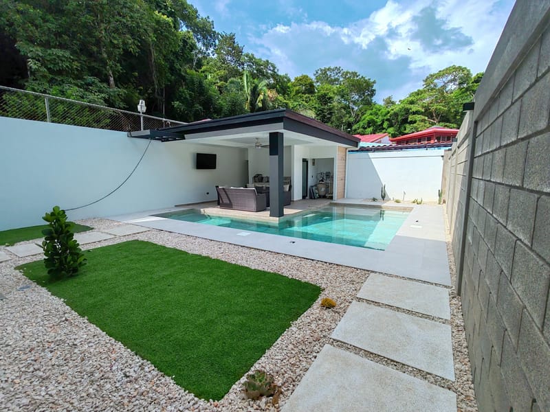 Salt water pool with artificial turf and the rancho behind it at Lapas Leona Home, Punta Leona