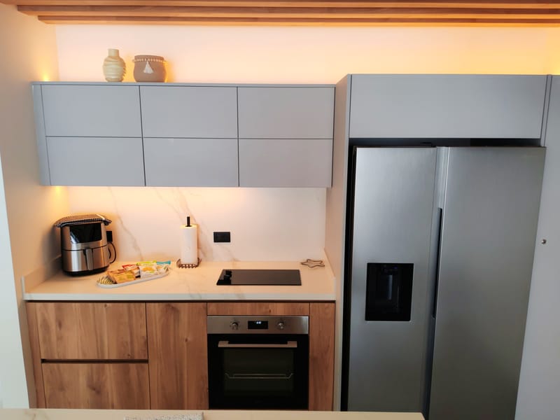 White kitchen with oven, air fryer and stainless refrigerator