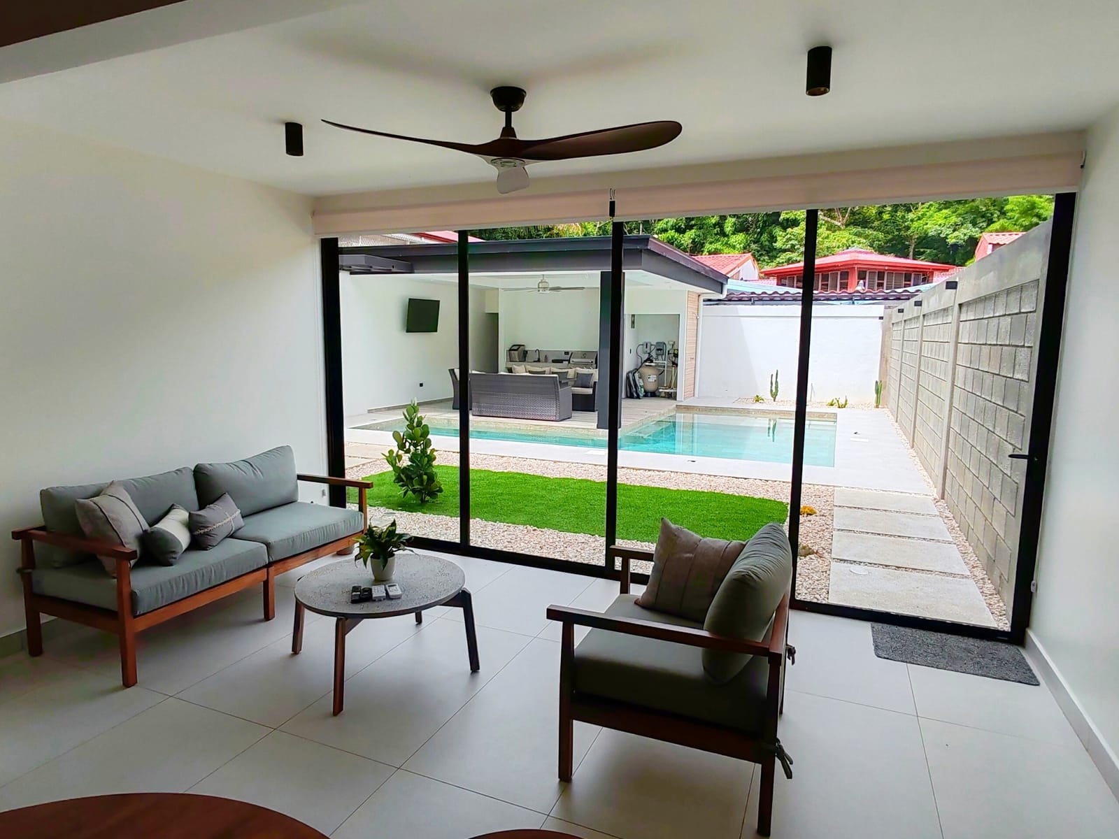Living room with sofa opening to the pool and turf