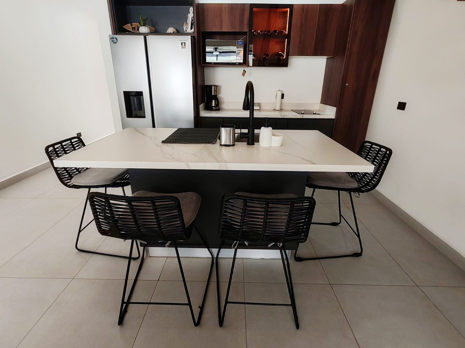 Second kitchen with dark cabinets and black bar stools